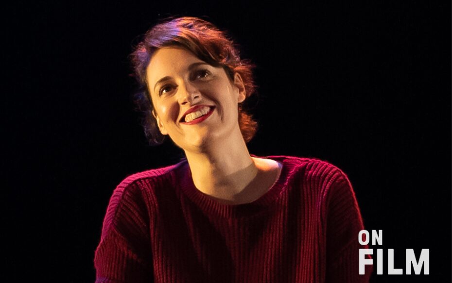 Phoebe Waller-Bridge in Fleabag, wearing a red sweater and lipstick. She is smiling.