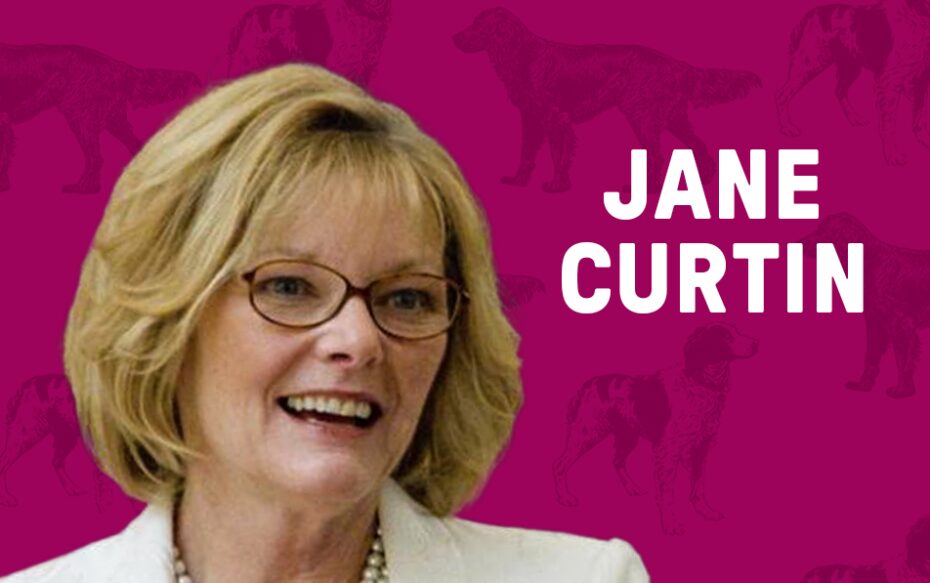 Against a magenta background, patterned with dogs: a headshot of Jane Curtin. White text of her name floats beside her headshot.