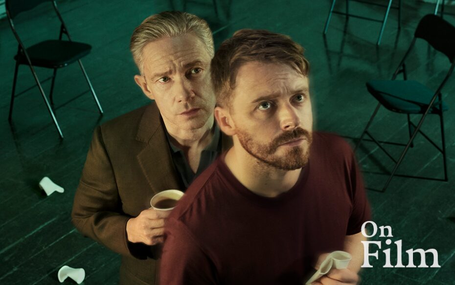Jack Lowden and Martin Freeman in The Fifth Step. Freeman is holding a cup of coffee, and there are black folding chairs in the background.