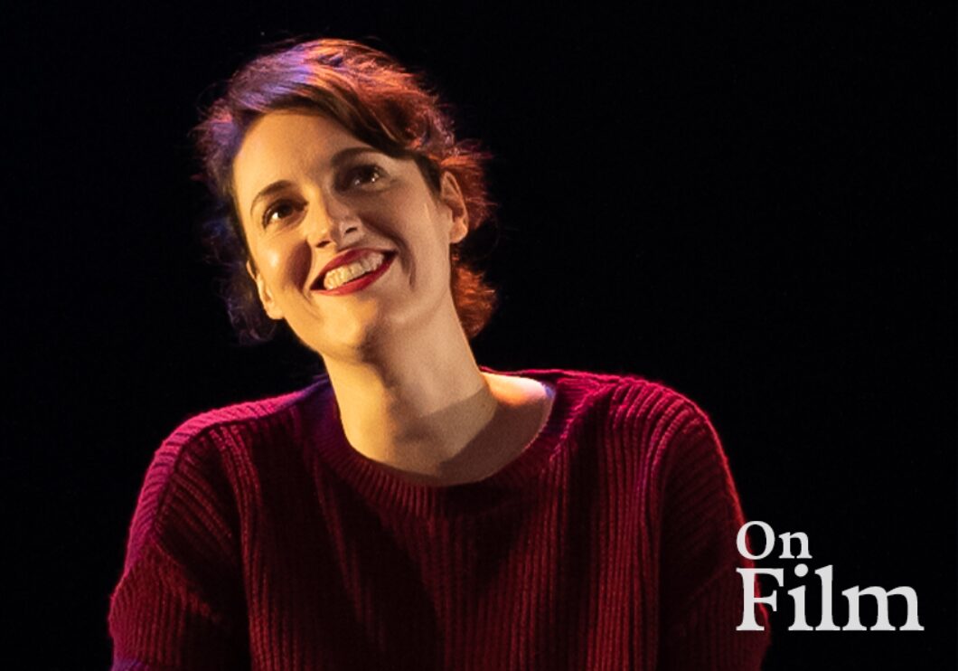 Phoebe Waller-Bridge in Fleabag, wearing a red sweater and lipstick. She is smiling.