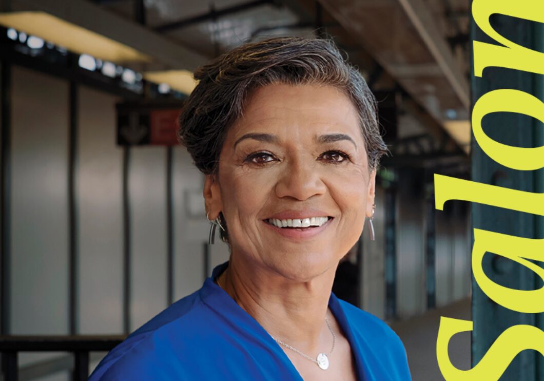 Sonia Manzano stands on a subway platform, smiling next to the word 'Salon' written in yellow lettering.