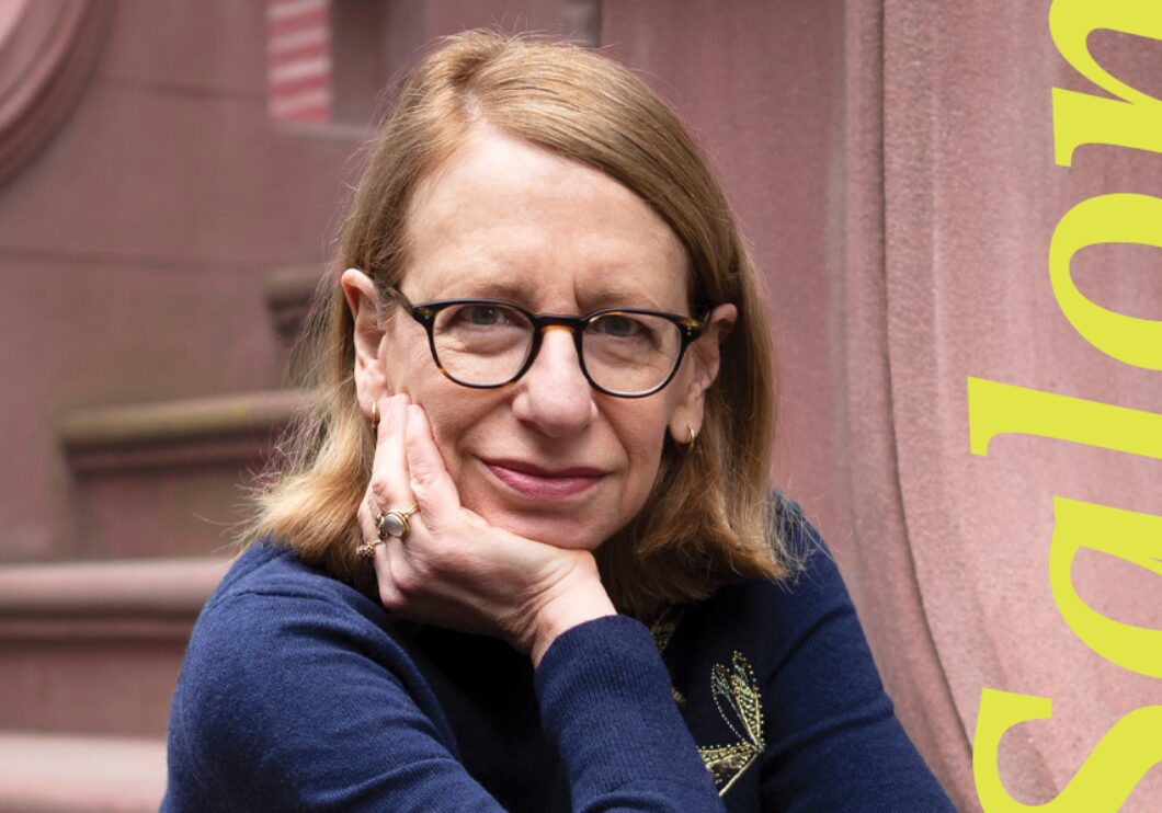 Roz Chast sits on the steps of a brownstone, one hand on her cheek, with 'Salon' written in yellow letters next to her.