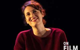 Phoebe Waller-Bridge in Fleabag, wearing a red sweater and lipstick. She is smiling.