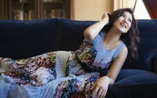 Pianist Min Kwon reclines on a navy blue couch.