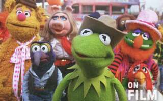 A still from The Muppet Movie, featuring Fozzie Bear, Gonzo, Miss Piggy, Kermit the Frog, and more.