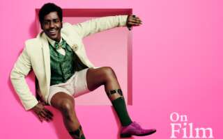 Ncuti Gatwa in The Importance of Being Earnest, in front of a pink background.