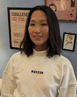 Alicia Sola Kim photo smiling with a white shirt that says "museum"
